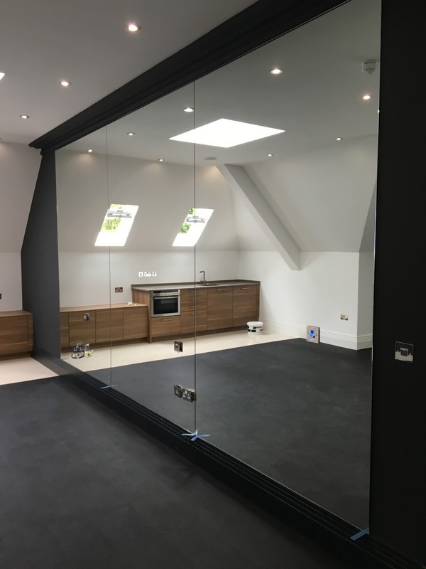 Frameless glass partition in loft conversion by Hither Green glaziers